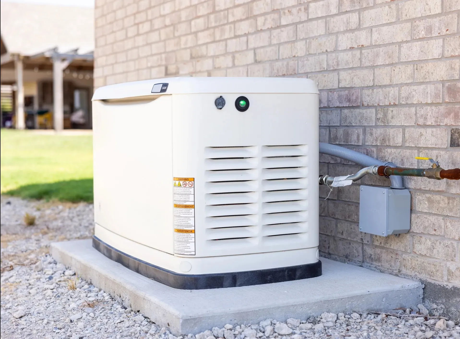 A home standby generator installed on a concrete pad beside a brick house